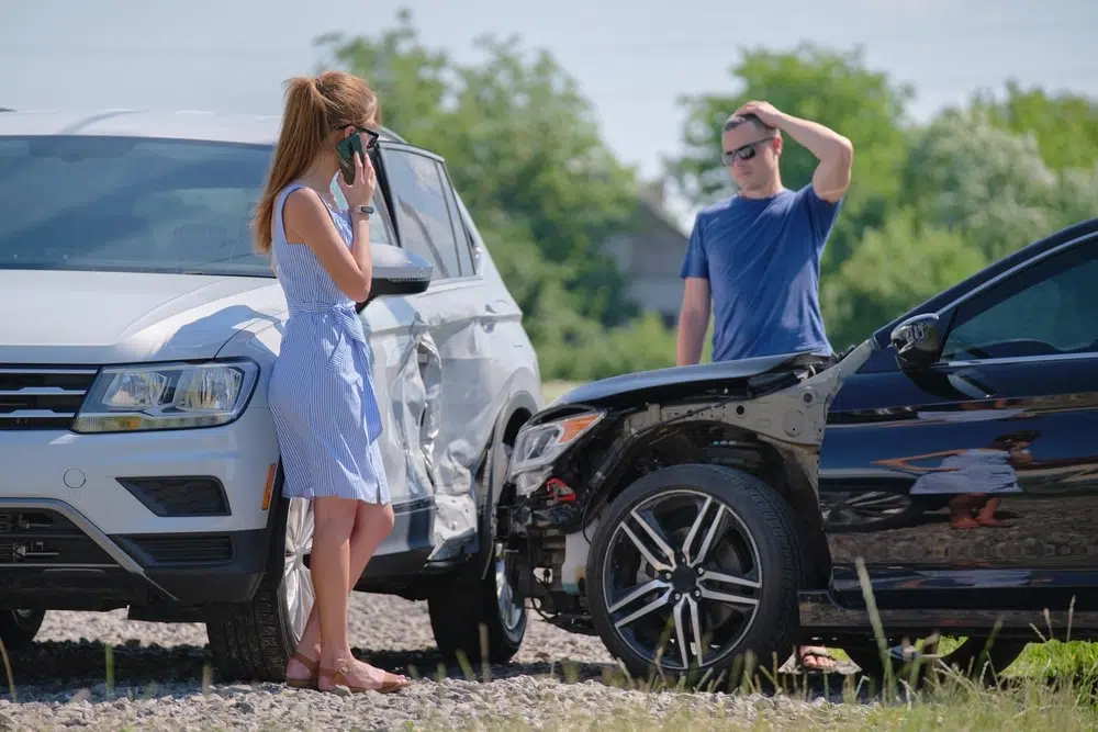 Drivers of smashed vehicles arguing who is guilty in car crash accident on street side.